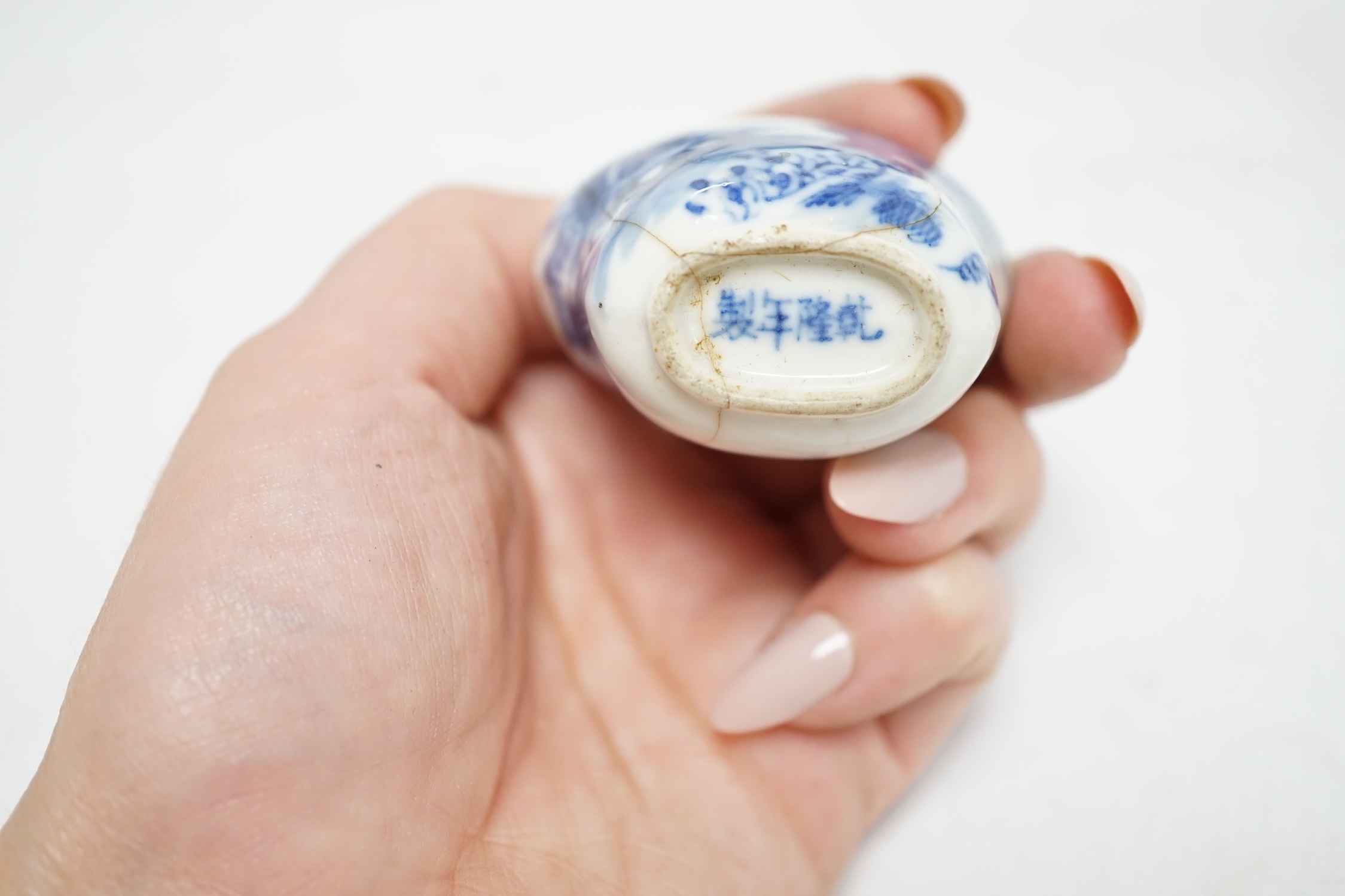 Three Chinese blue and white snuff bottles and three hardwood stands, largest 8cm high. Condition - poor to fair